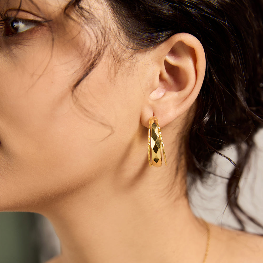 Model wearing Aveera designer gold plated textured oval hoop earrings, adding a chic touch to an everyday outfit.