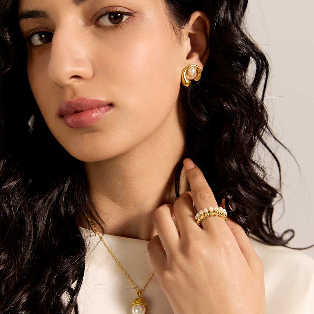 Model wearing Aveera designer gold tone crossover ring, emphasizing its unique design.
