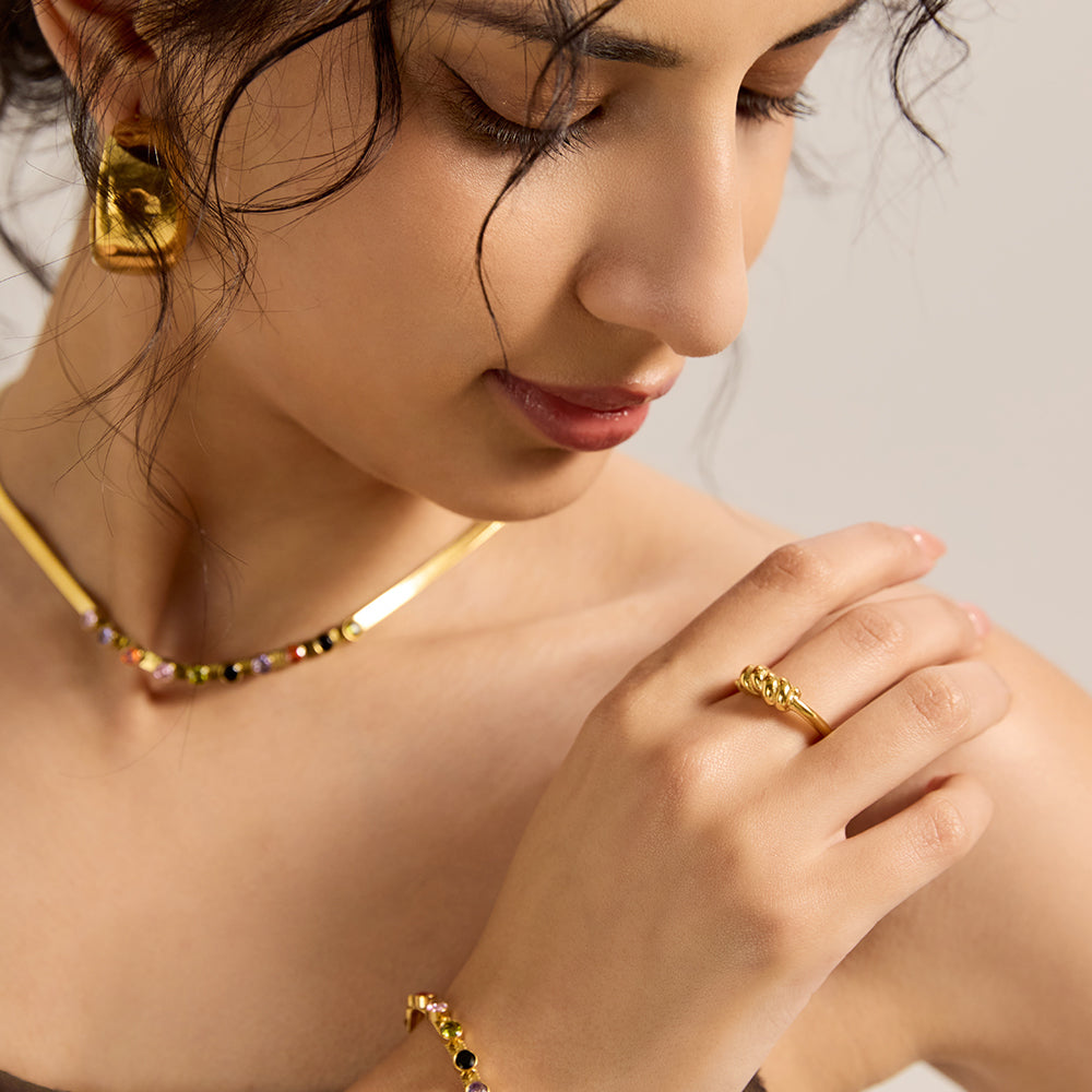 Model wearing Aveera designer gold tone irregular textured ring, emphasizing its statement design.