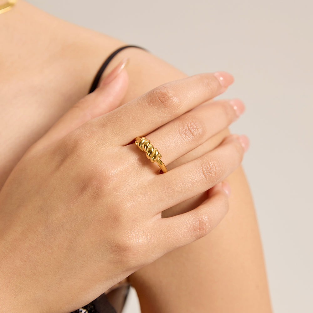 Model wearing Aveera designer gold tone irregular textured ring, showcasing its unique fit and modern appeal.

