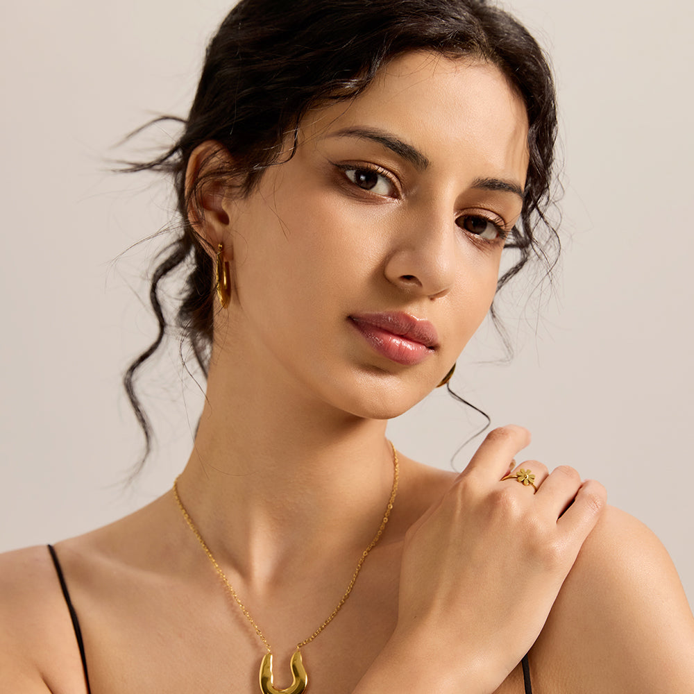 Model wearing Aveera designer gold tone small flower adjustable ring, showcasing its charming fit and style.