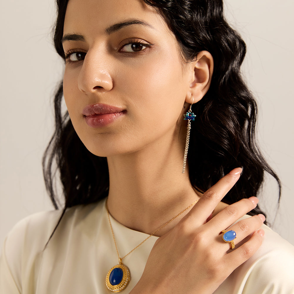 Model wearing Aveera designer gold tone triple circle blue stone ring, showcasing its elegant fit and modern appeal.