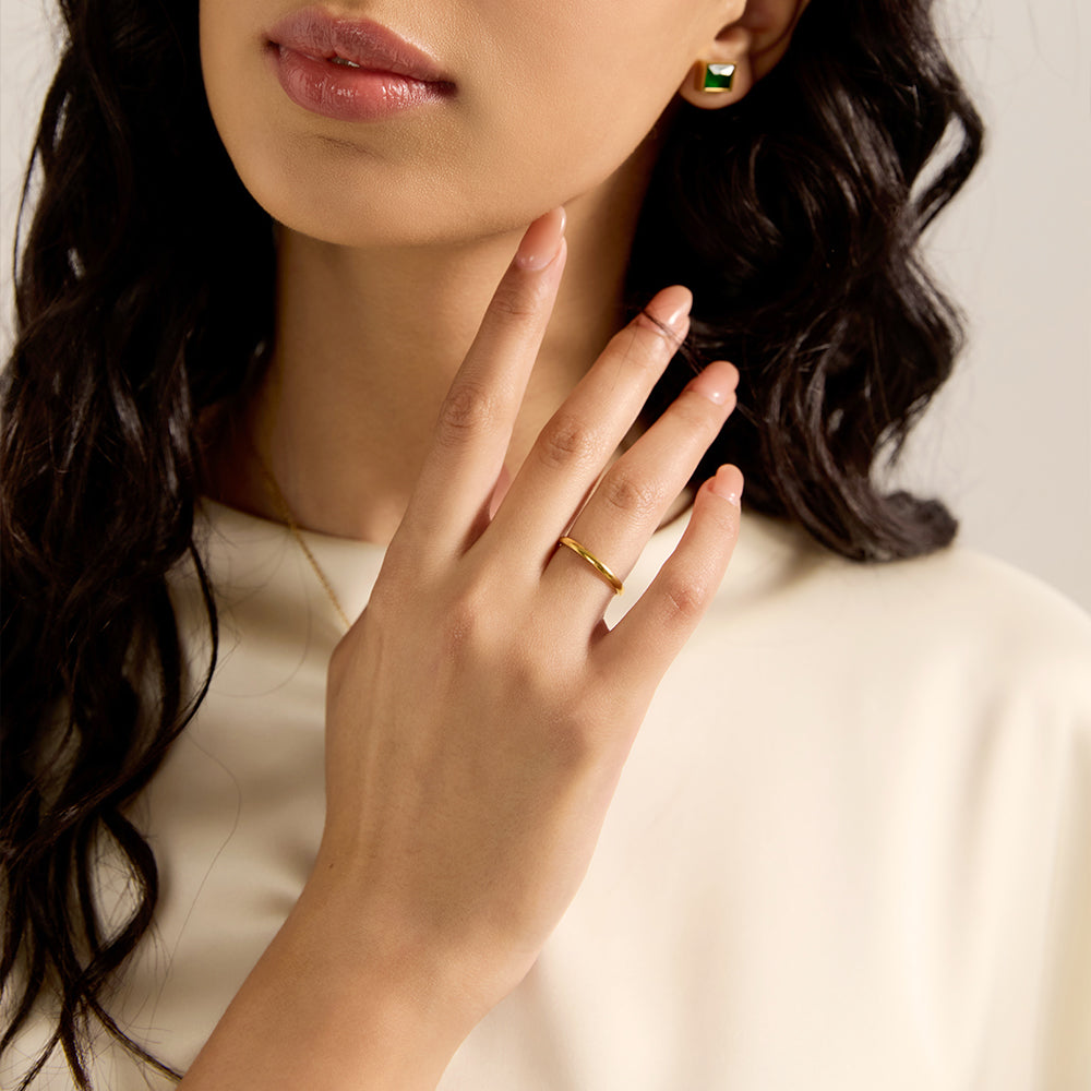 Model wearing Aveera designer plain gold tone copper alloy band ring, showcasing its sleek fit and simple elegance.