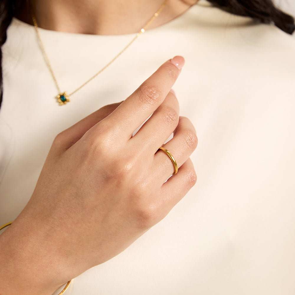 Close-up of Aveera designer plain gold tone copper alloy band ring, highlighting its polished finish and modern design.