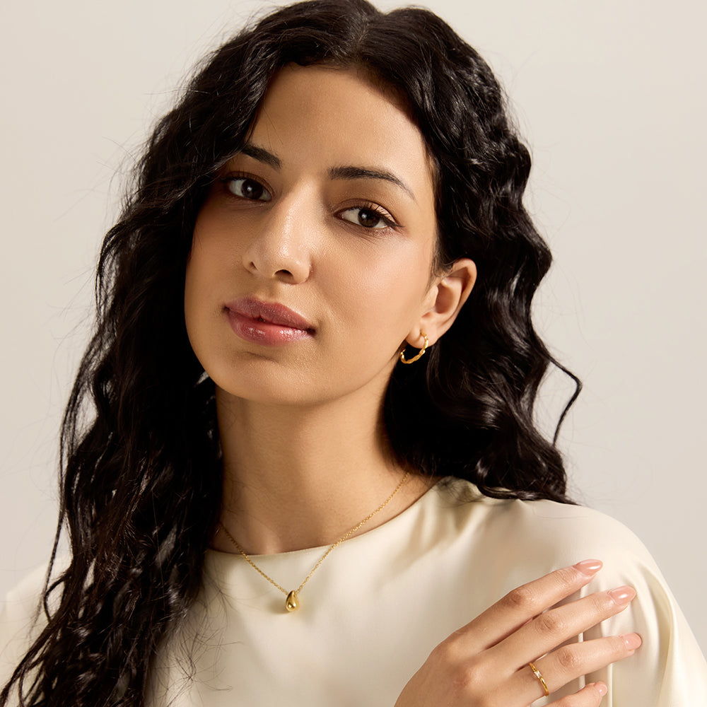 Model wearing Aveera designer silver-tone serpent earrings, matching snake ring, and serpent bracelet, elegant full look.
