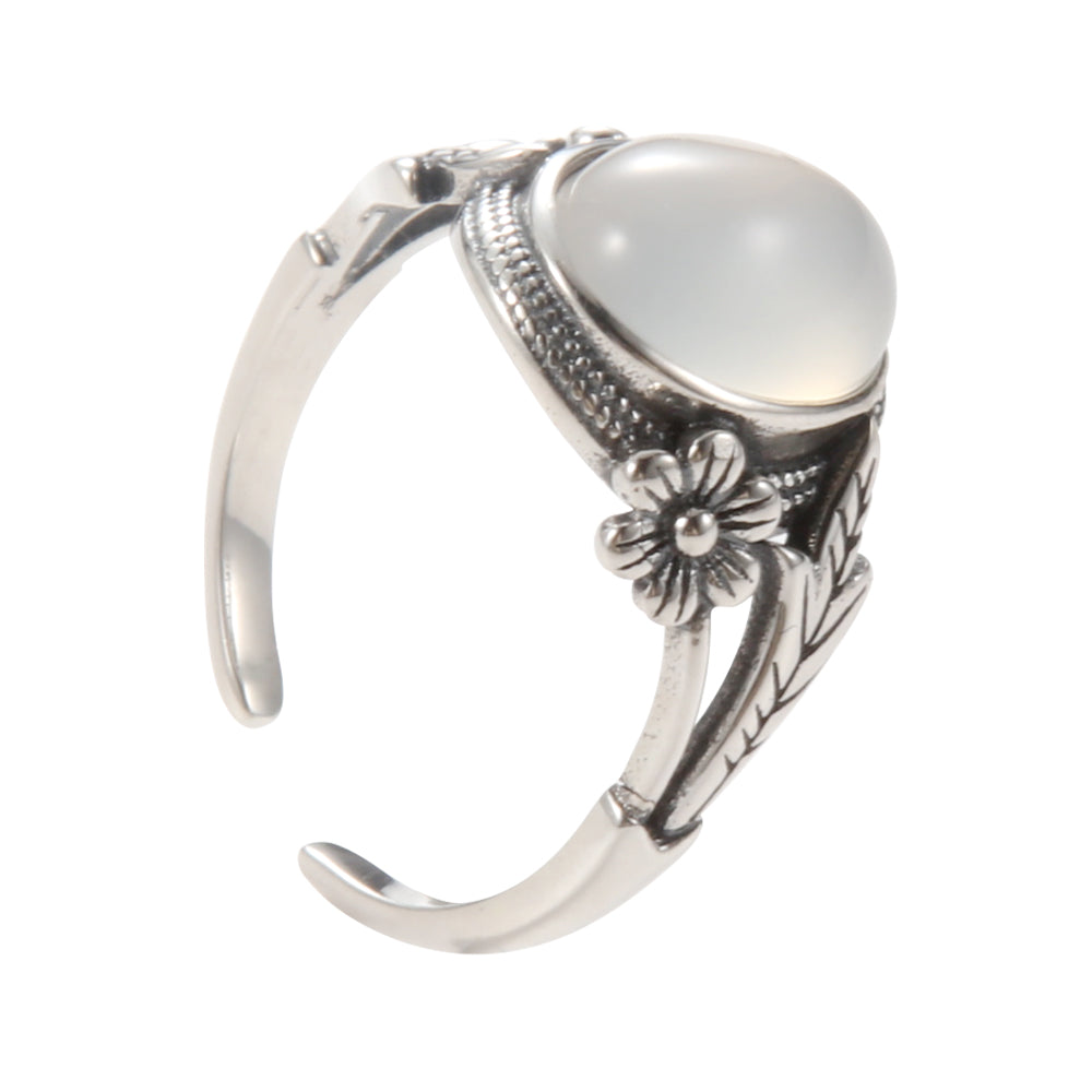 Aveera unique designer silver tone ring featuring a large oval luminous white stone with intricate floral engravings.