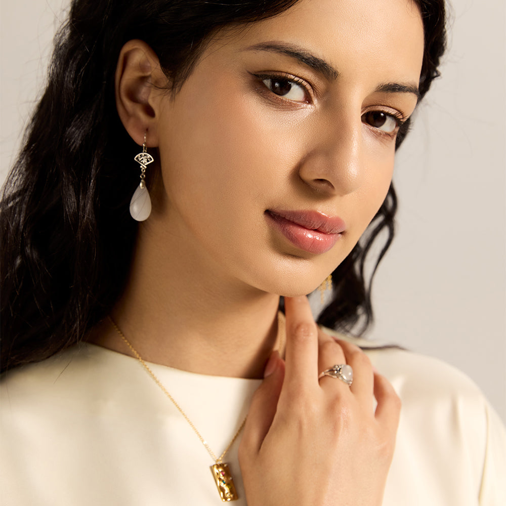 Model wearing Aveera designer silver tone oval luminous white stone floral ring, highlighting its captivating presence on hand.