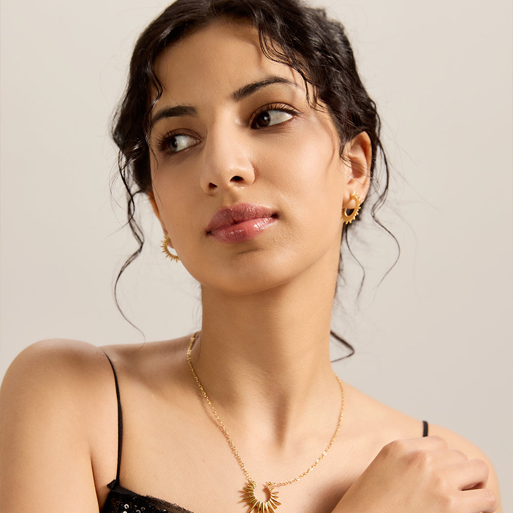 Model wearing Aveera designer gold plated sunburst textured half hoop earrings, for an elevated everyday look.Model wearing Aveera designer gold plated sunburst textured half hoop earrings, for an elevated everyday look.

