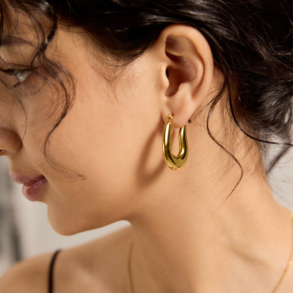 Model wearing Aveera designer gold plated twisted hoop earrings, adding a chic touch to everyday look.