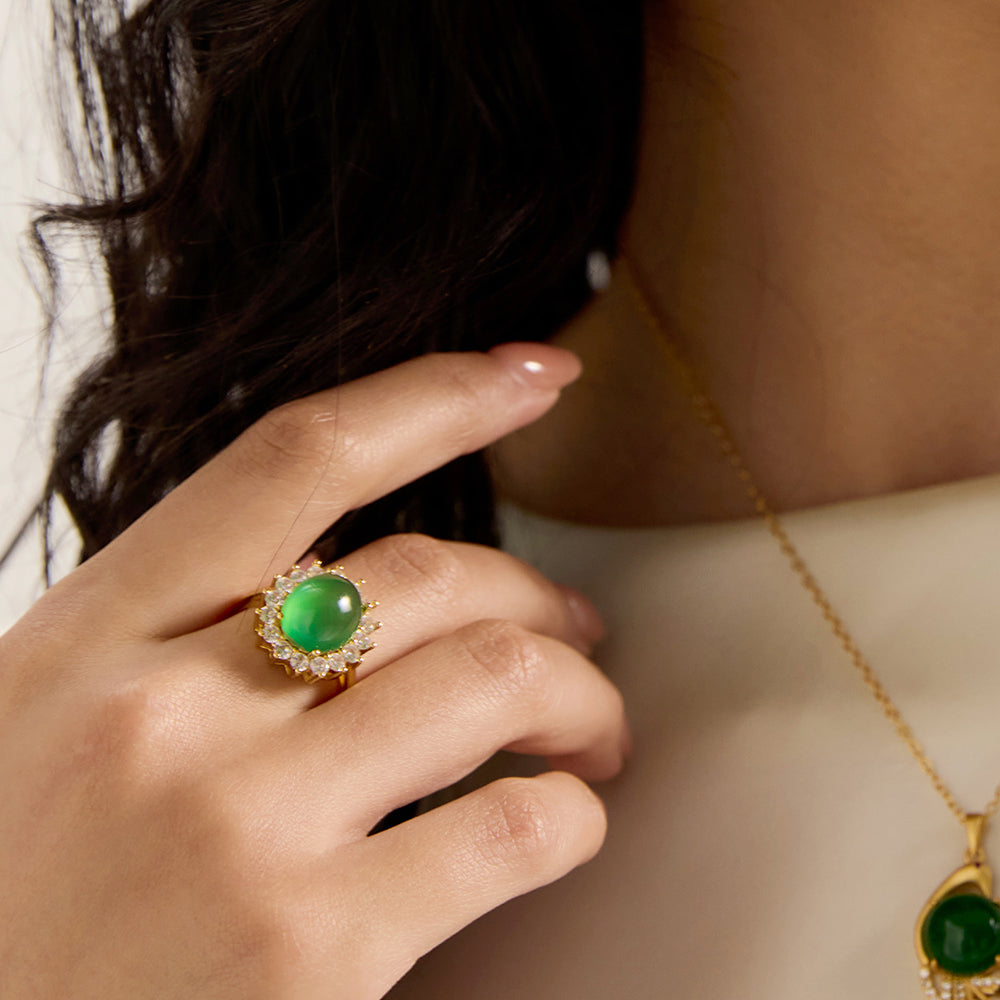 Model wearing Aveera gold tone green gemstone adjustable ring, showcasing its elegant fit and vibrant green stone on hand.