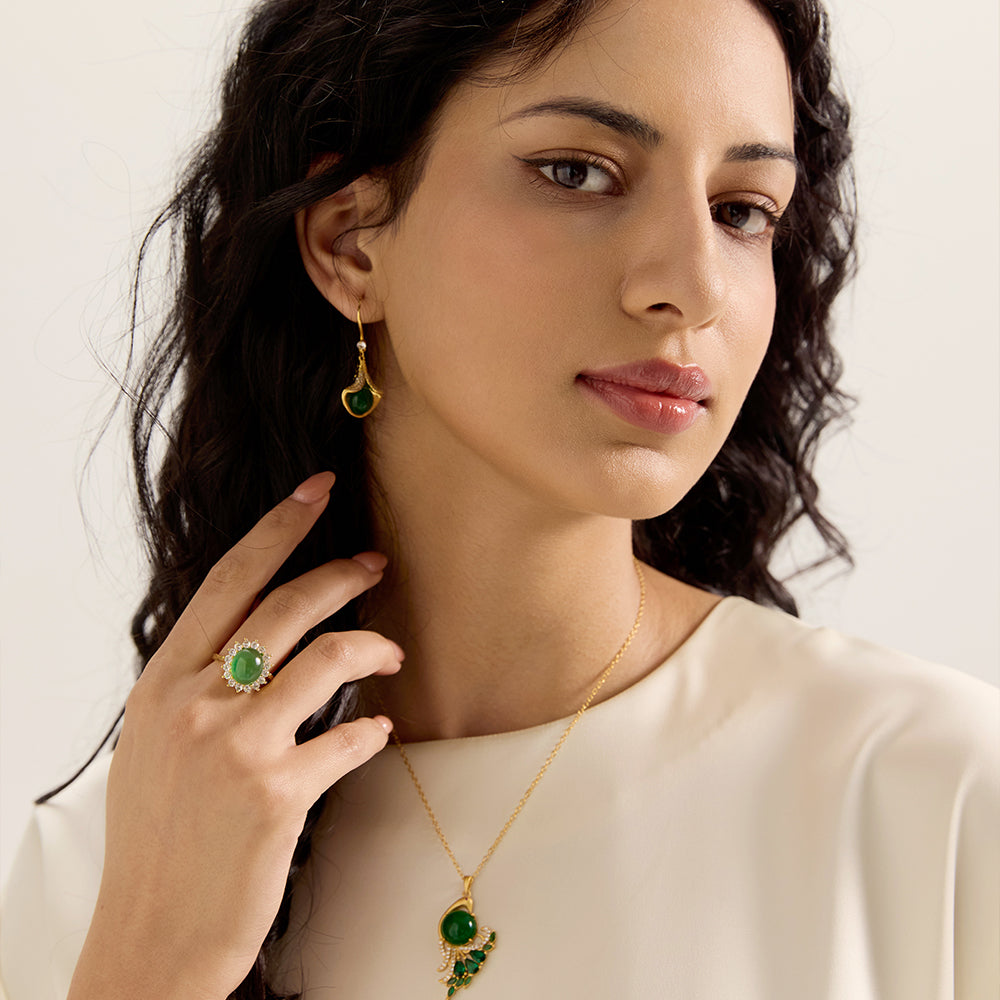 Model displaying Aveera gold tone green gemstone adjustable ring as part of a stylish outfit, highlighting its overall look.