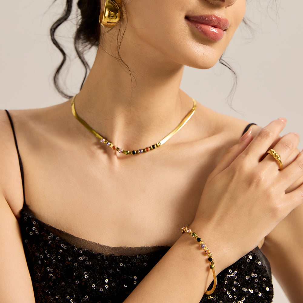Another view of model wearing Aveera gold tone snake chain bracelet with colorful gemstones, emphasizing its overall style.