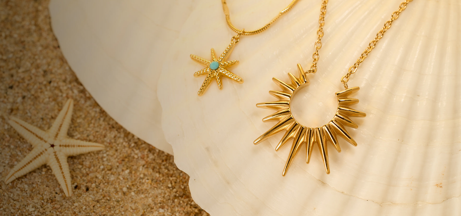 Close-up of the Aveera Jewelry sun and starfish pendant necklace, inspired by the ocean and nature, displayed on a seashell.