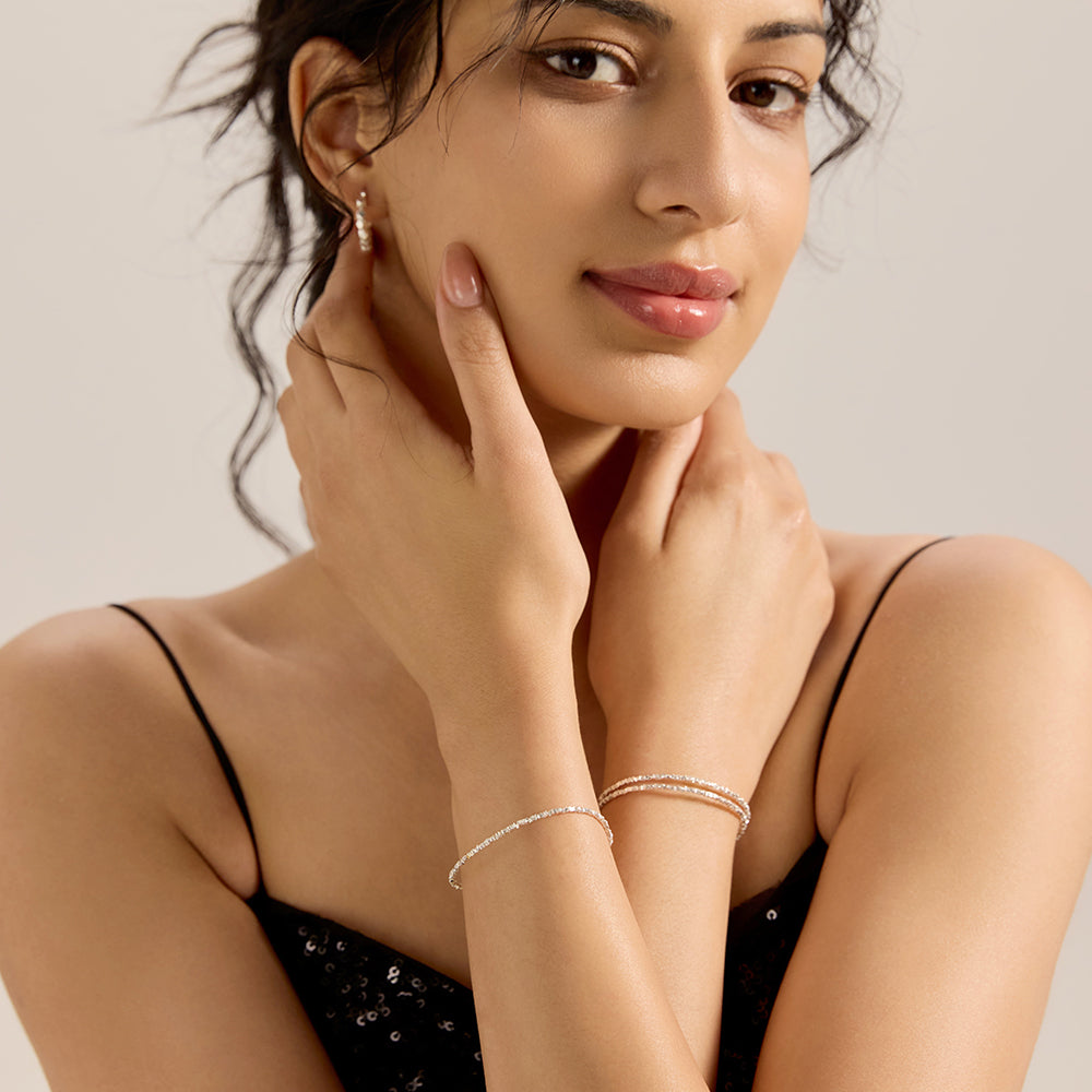 Model wearing Aveera silver tone pave chain bracelet with hands crossed, demonstrating its stylish and versatile wear