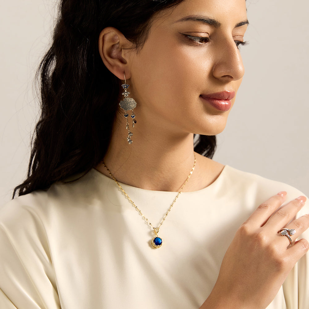 Woman wearing gold tone blue sapphire disc necklace from another angle, emphasizing its serene beauty and connection to higher truth.
