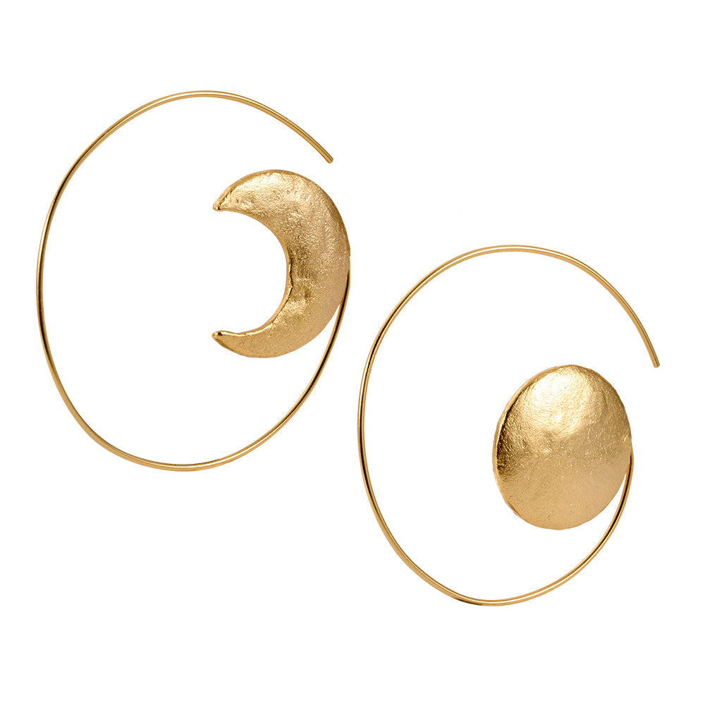 Close-up of gold celestial hoop earrings showing textured sun and moon elements.