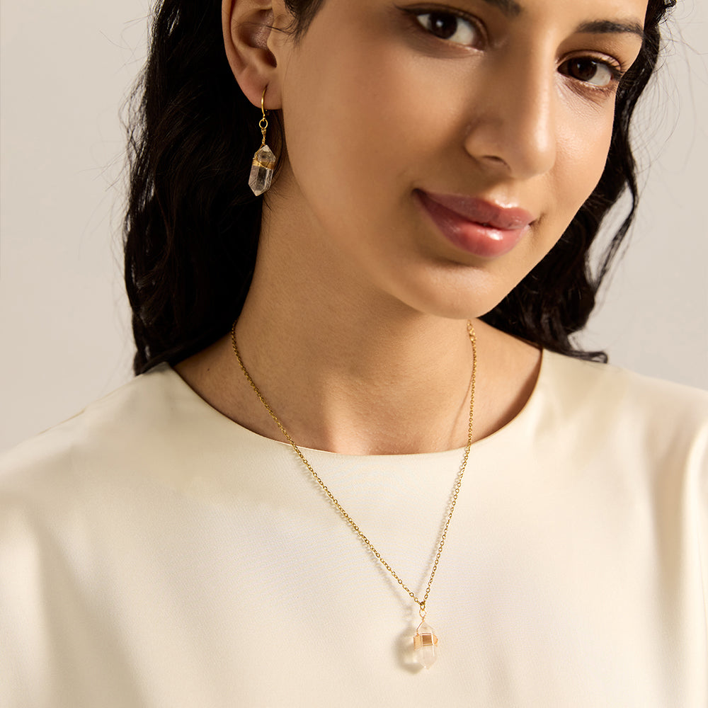 Woman modeling gold tone clear quartz crystal point necklace, showcasing its minimalist elegance and spiritual presence.