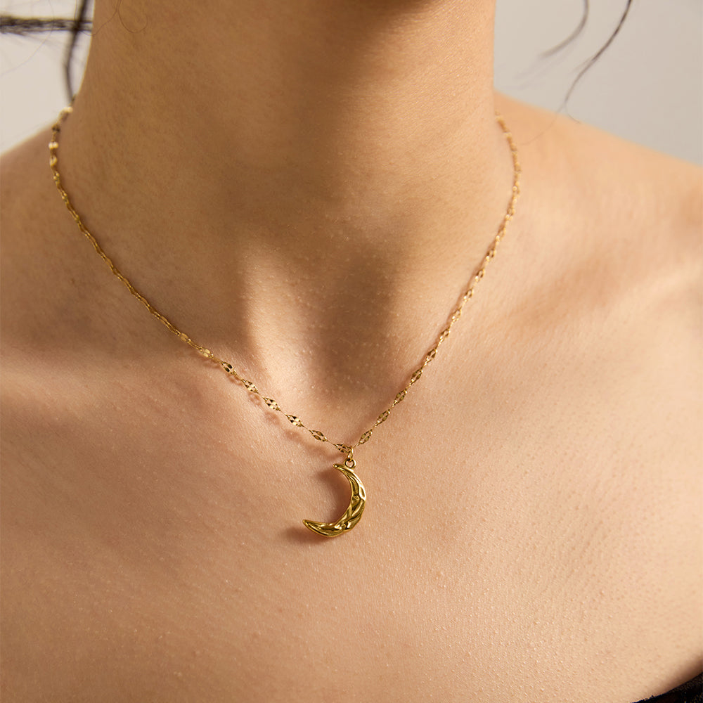 Woman wearing elegant gold tone crescent moon necklace, showing moon and sparkle.
