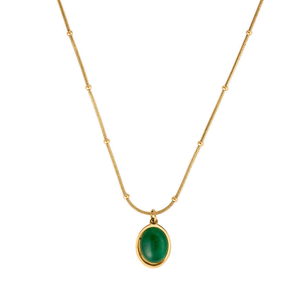 Elegant gold tone necklace with a vibrant oval green gemstone pendant on a dainty beaded chain, flat lay.