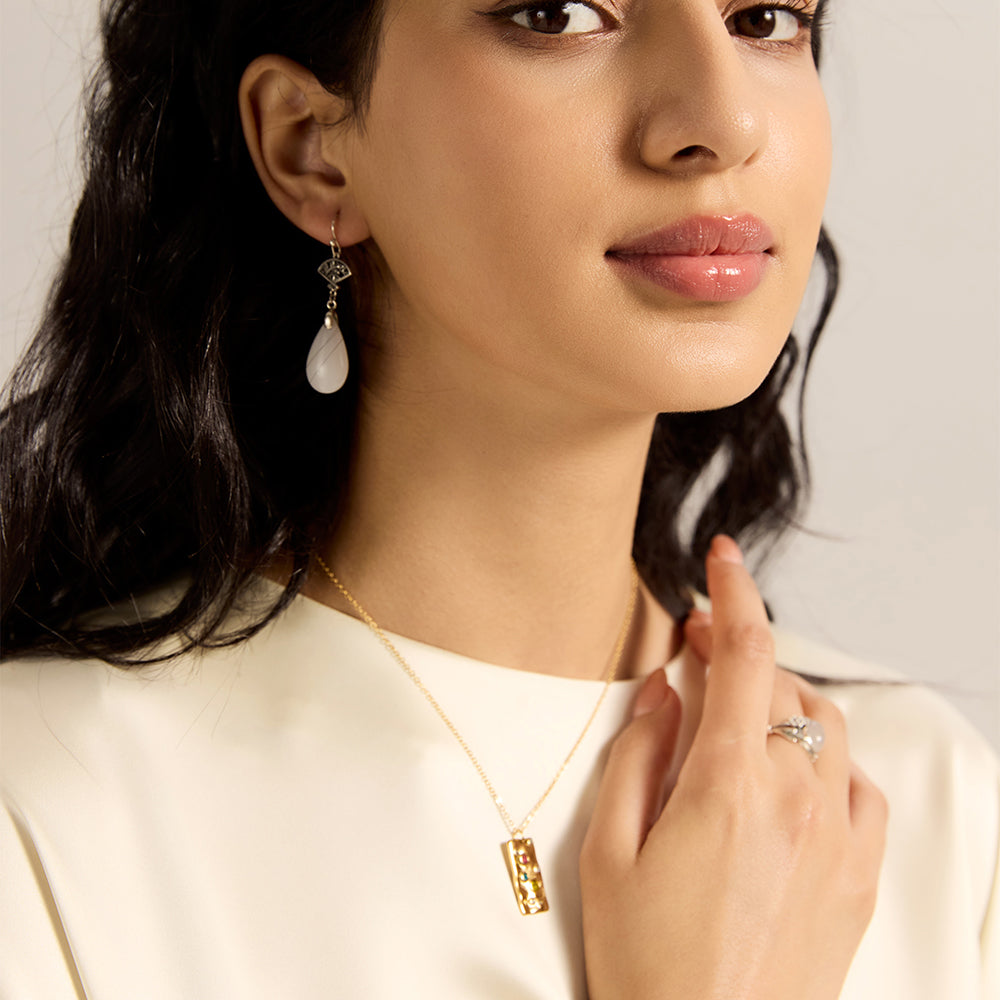 Woman modeling gold tone hammered rectangular energy necklace with multi-color crystals, showcasing its powerful spiritual and aesthetic appeal.