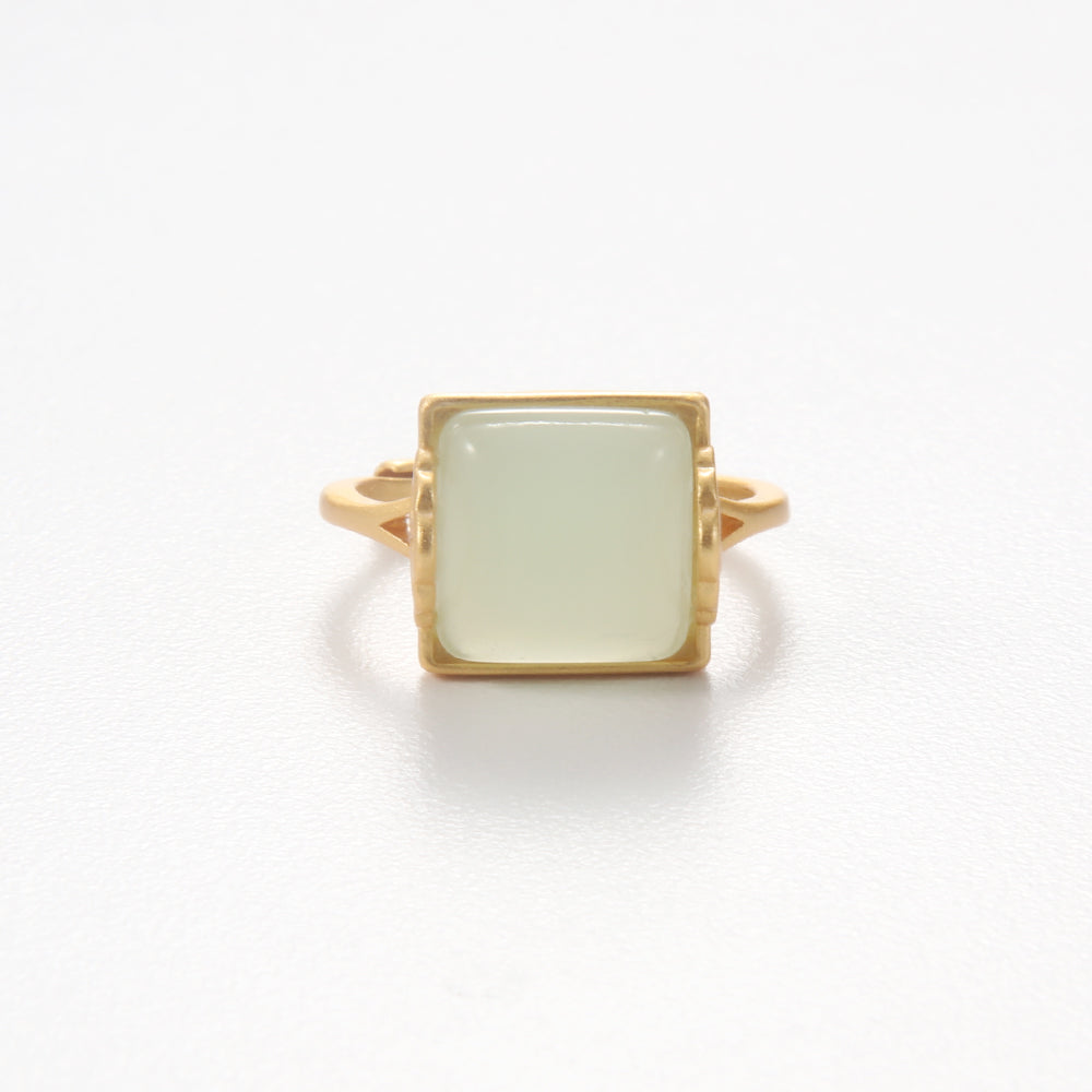 Gold tone ring with a prominent square natural jade or light green gemstone, symbolizing serenity and good fortune.