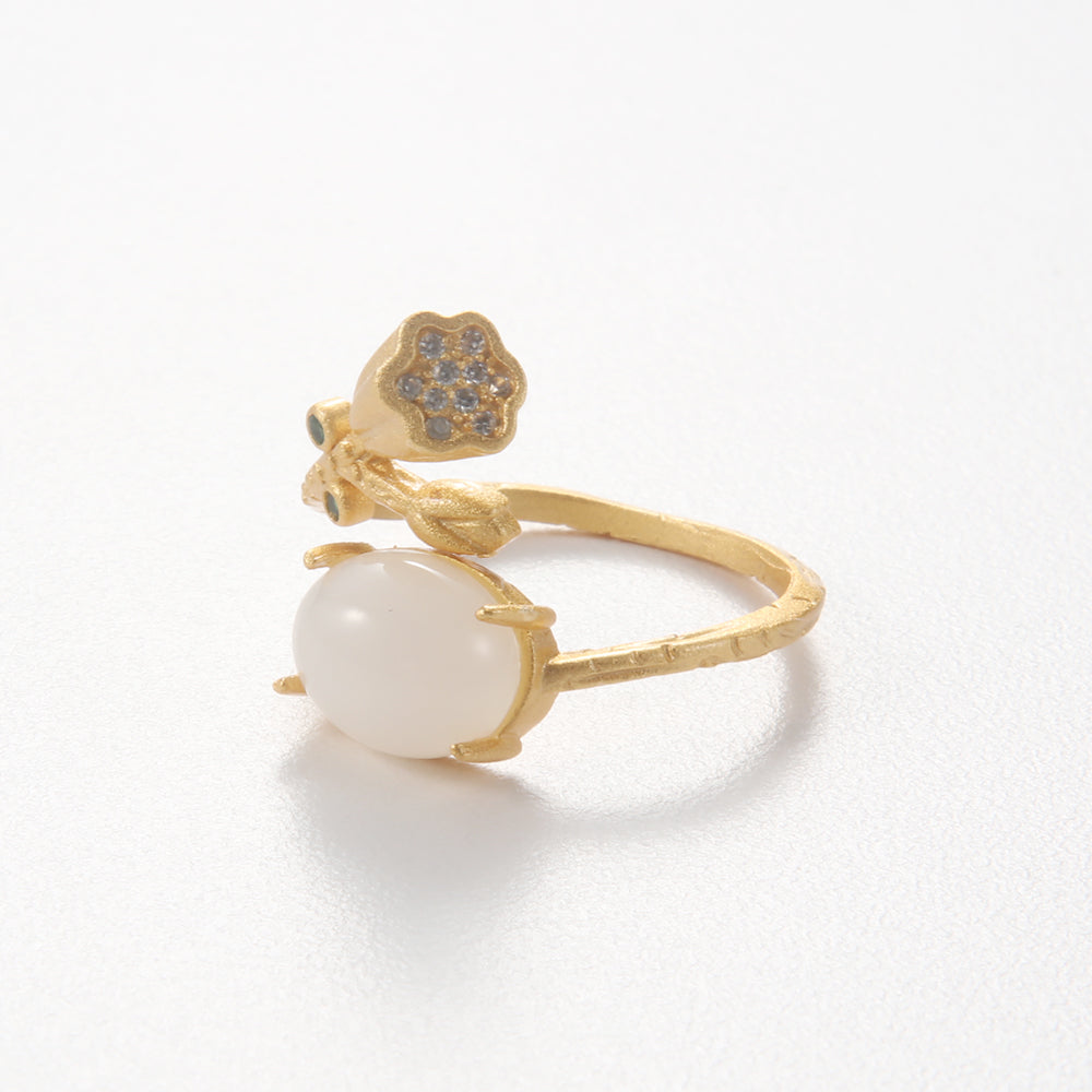Gold tone ring featuring a lotus pod design with a central round white gemstone, symbolizing spiritual purity and growth.