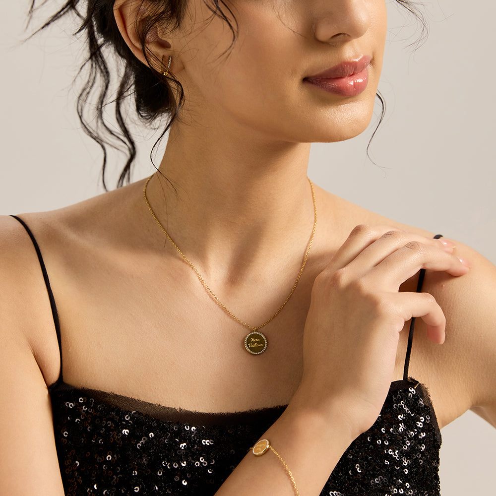 Woman wearing gold tone "MERE MEILLEURE" necklace with matching jewelry.
