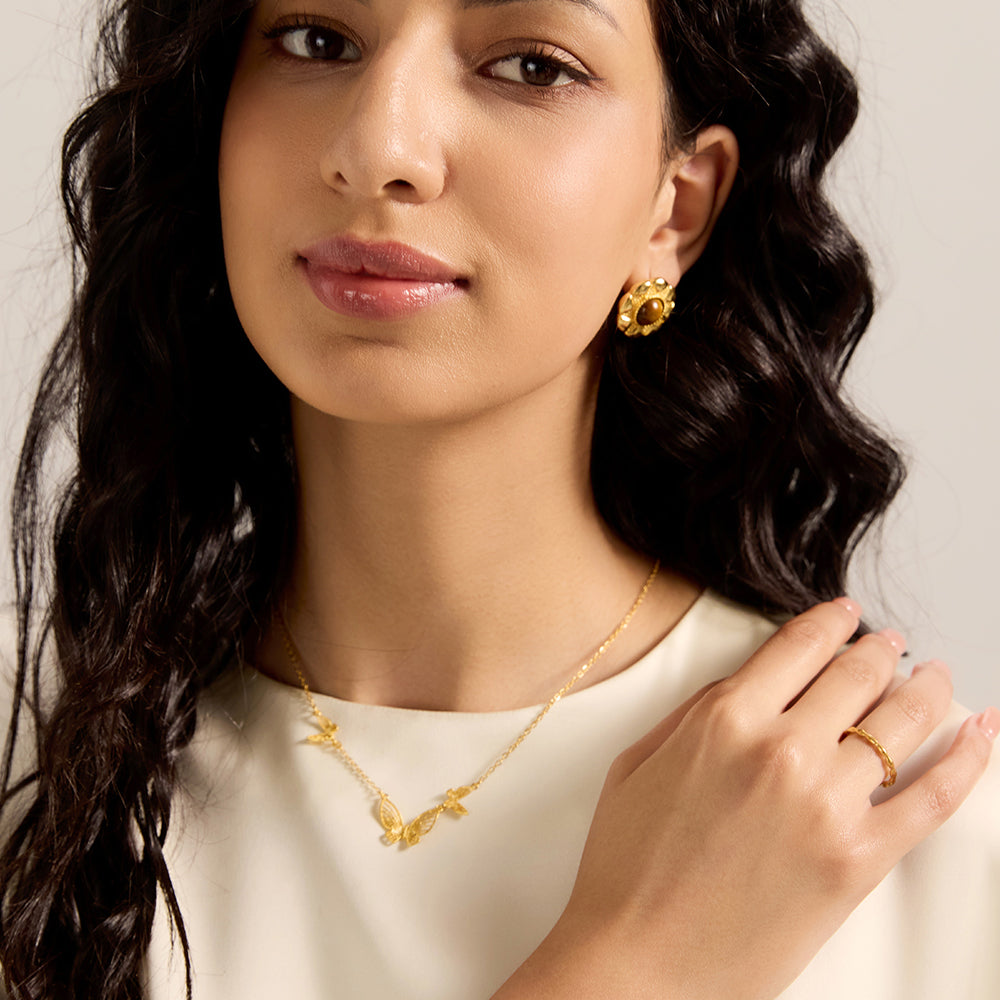  Woman modeling gold tone multi-butterfly necklace, showcasing its delicate and elegant look worn around the neck.