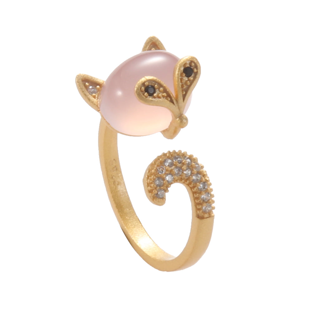 Gold tone open ring shaped like a fox, featuring an oval pink gemstone as its body and a sparkling pave tail.