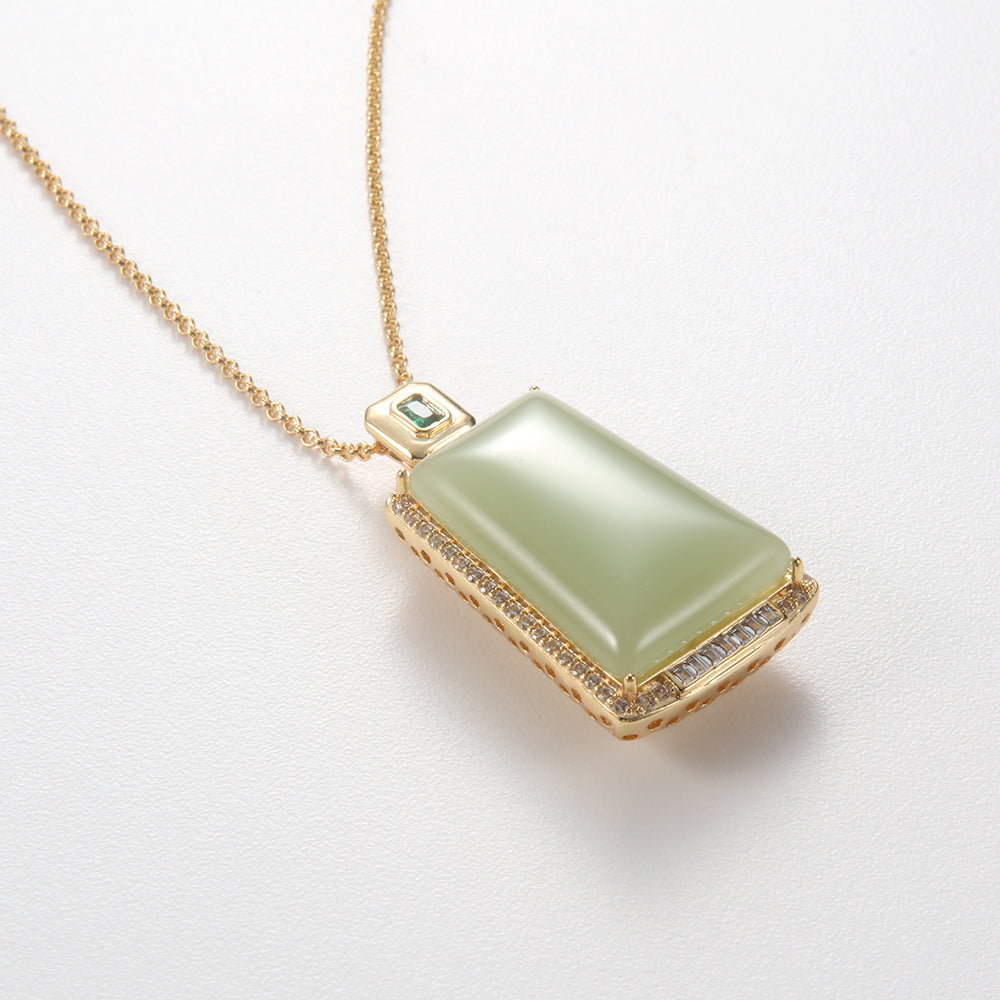 Elegant gold tone rectangle green gemstone necklace with pave crystal accents.