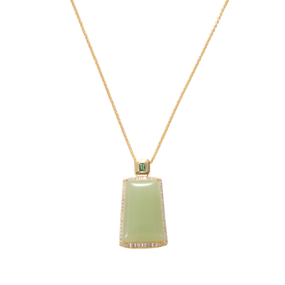 Close-up of gold tone rectangle green gemstone necklace, showing pave crystal details and top accent stone.