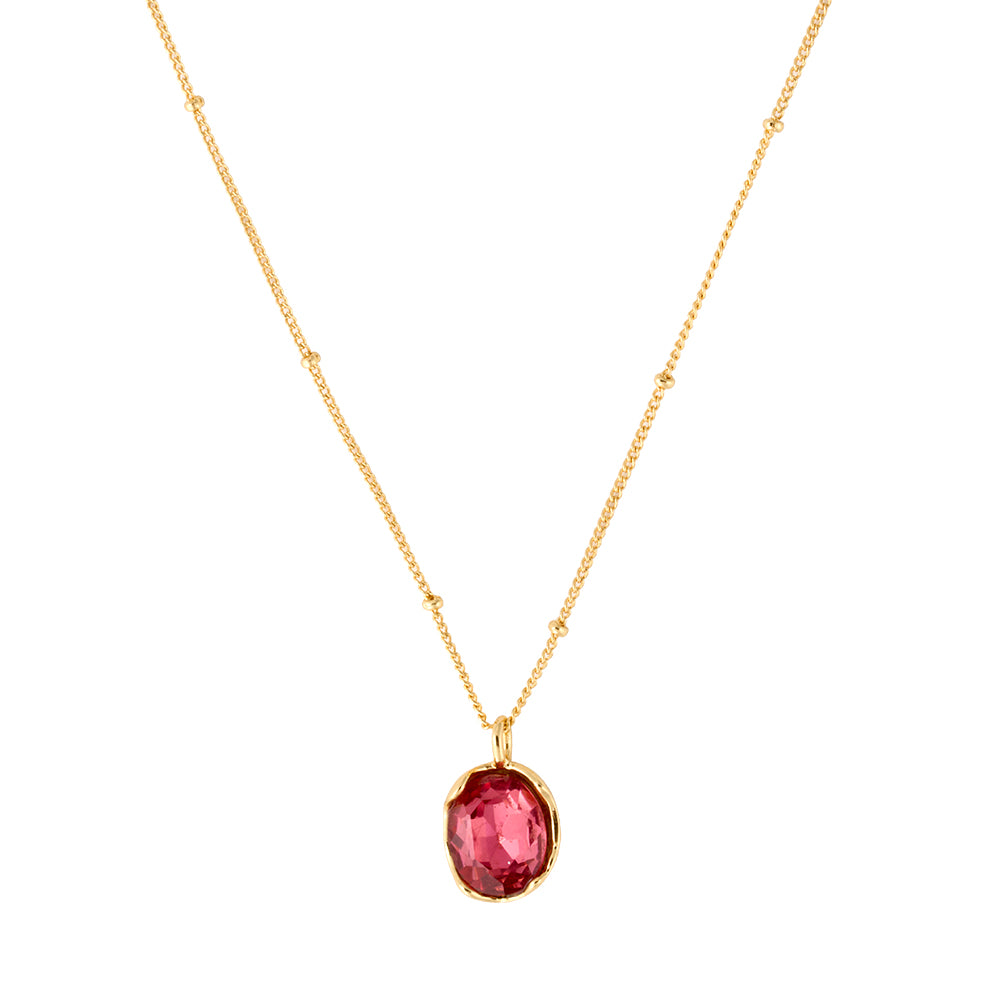 Elegant gold tone satellite chain necklace with oval red gemstone pendant.