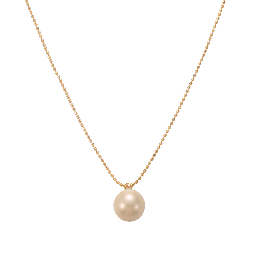 Gold tone necklace with a single, perfectly spherical freshwater pearl pendant, symbolizing purity, wisdom, and emotional balance, flat lay.