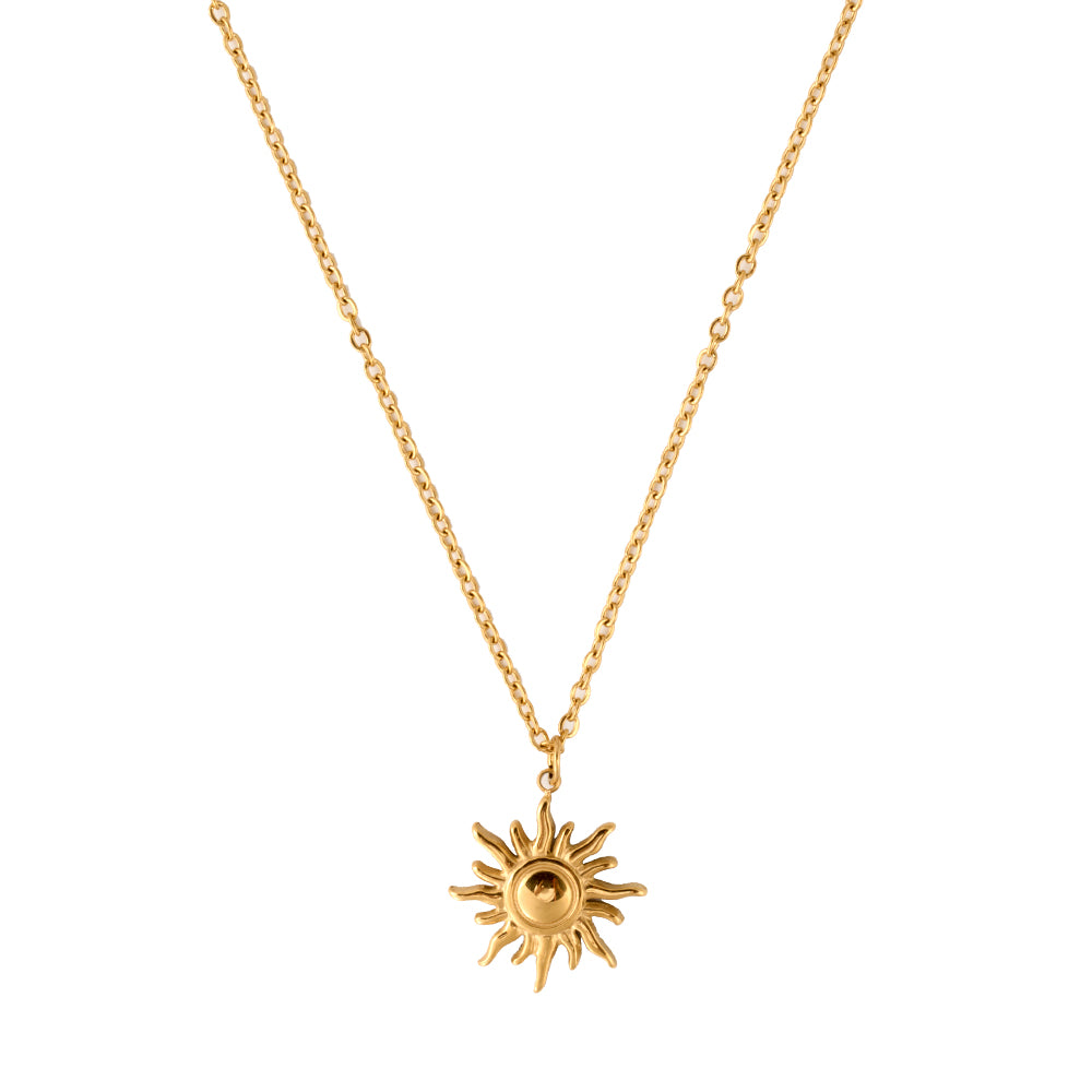 Radiant gold tone sunburst pendant necklace, symbolizing energy, vitality, and new beginnings, flat lay.