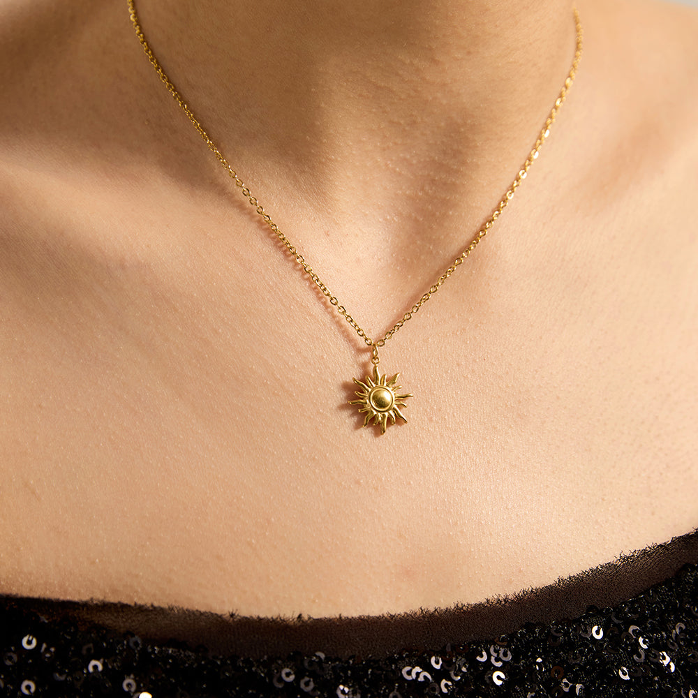Woman wearing gold tone sunburst power necklace, close-up highlighting the detailed sunburst pendant and its radiant energy.