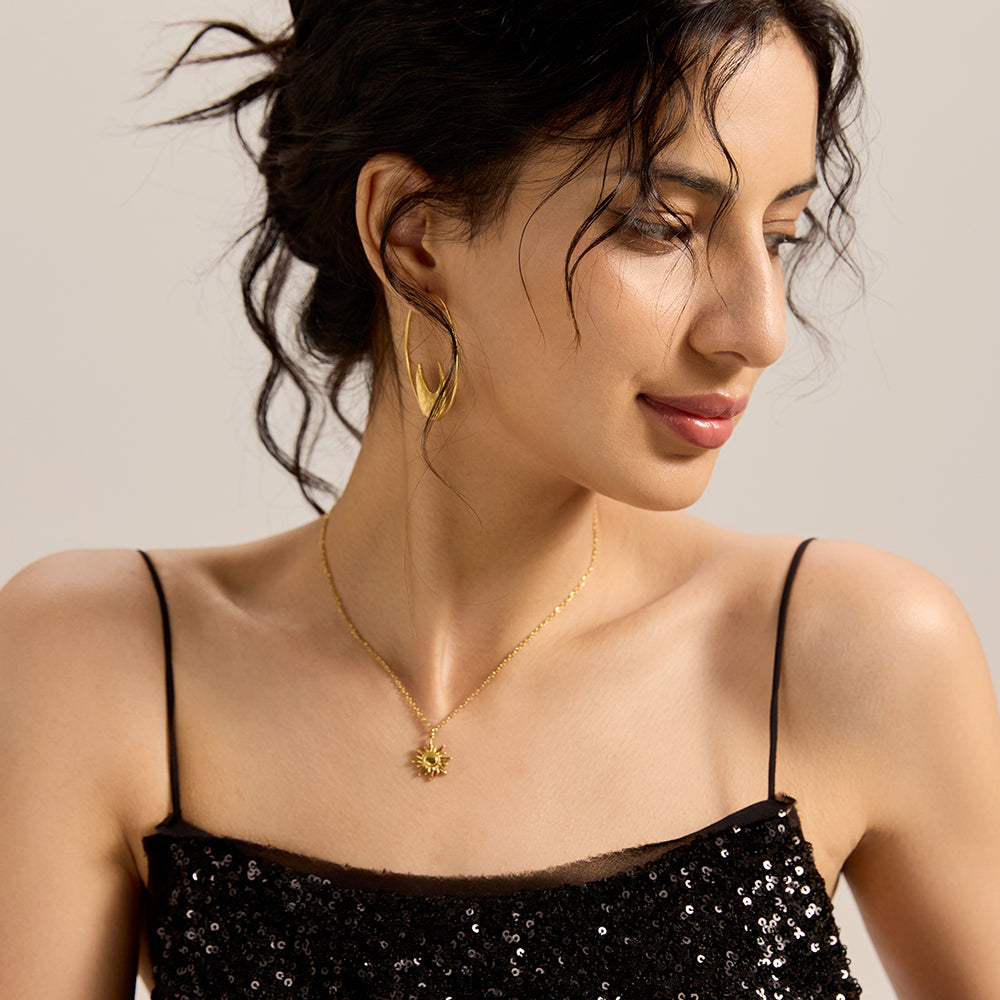  Woman modeling gold tone sunburst necklace, showcasing its elegant and empowering presence.