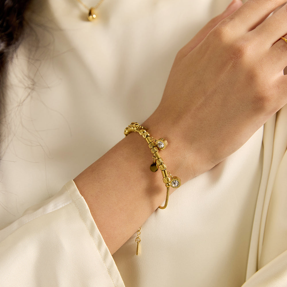 Woman wearing gold tone barrel bead bracelet, showcasing full design and fit.