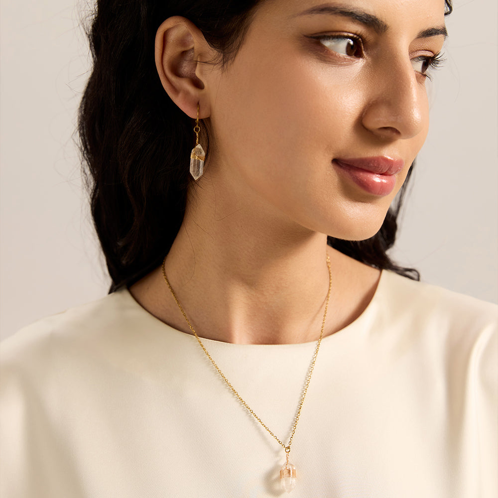 Woman wearing gold thin hoop earrings with natural wrapped crystal point dangles, showcasing their flow and positive aura.