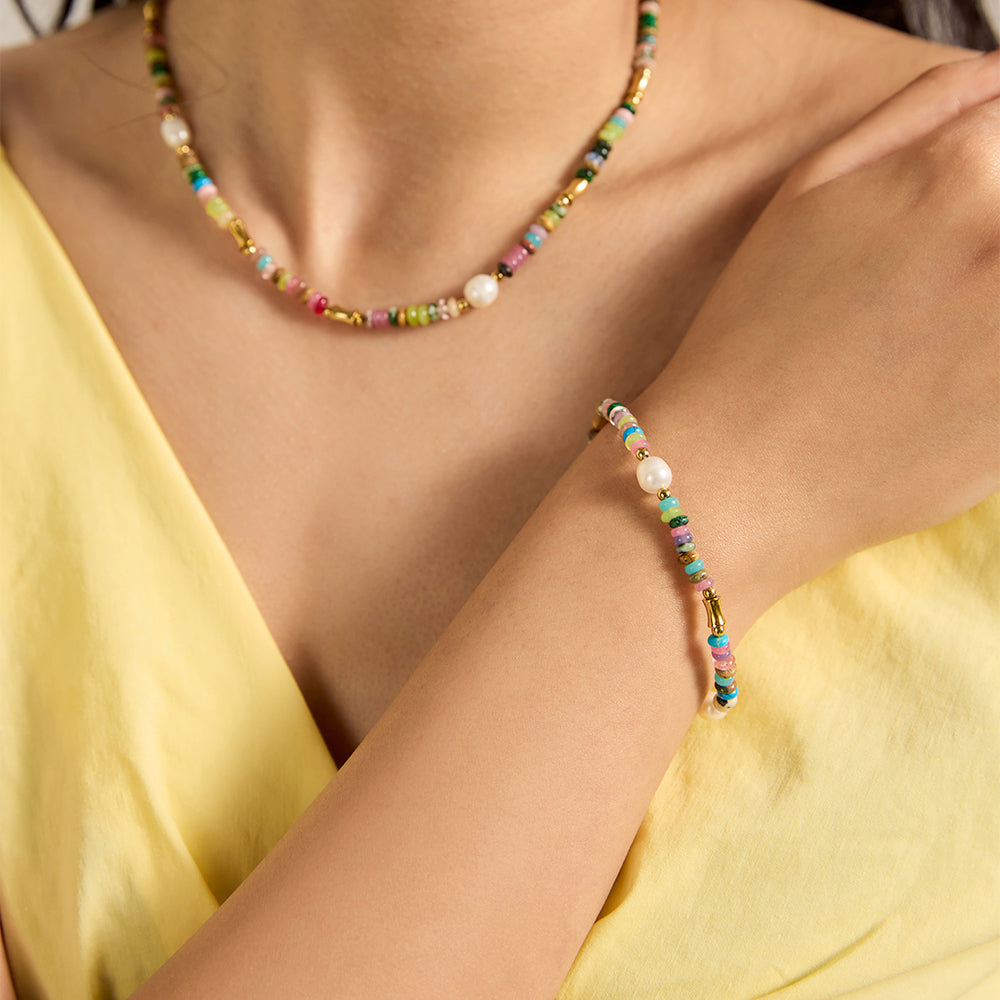  Woman wearing multi-color beaded bracelet with pearls and matching necklace.