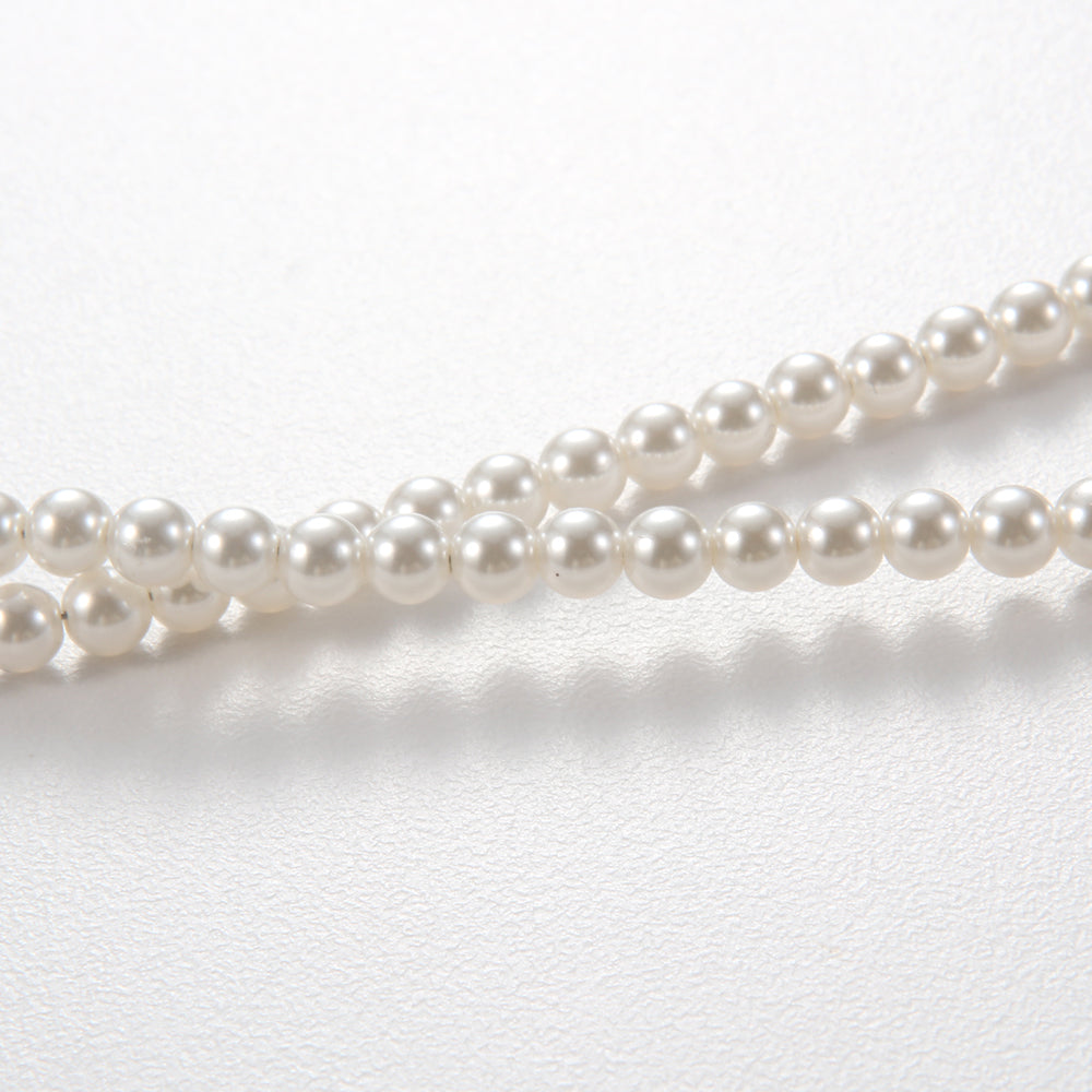 Close-up of the silver and red gemstone pendant on the pearl and red agate necklace, showing intricate details.