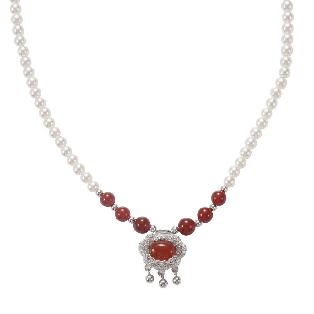 Elegant pearl and red agate beaded necklace with silver and red gemstone pendant.