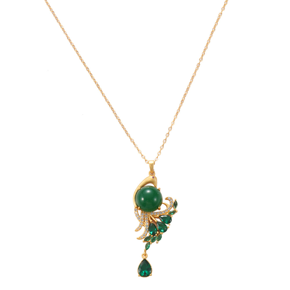 Woman wearing spiritual gold tone peacock green gemstone amulet necklace with matching ring and earrings.