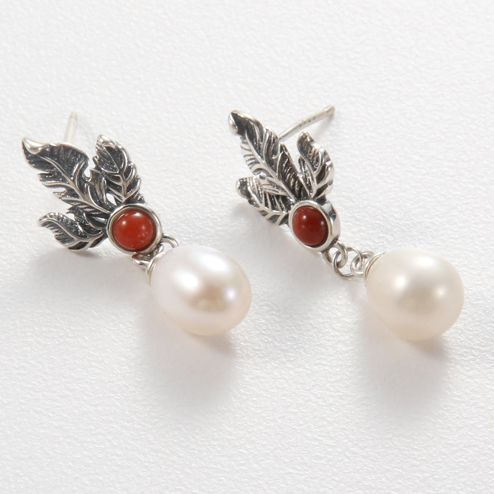 Pair of artisan sterling silver leaf and red gemstone drop earrings with freshwater pearls.