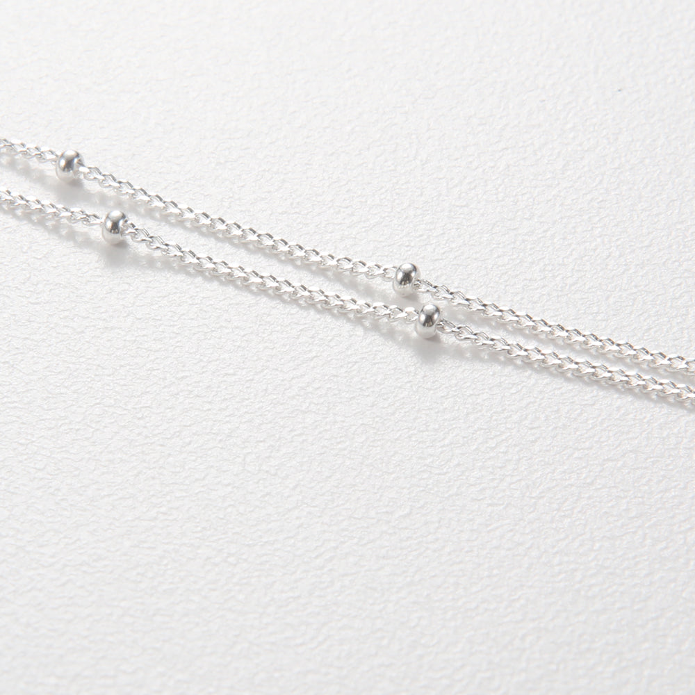 Overhead close-up of the sterling silver butterfly pendant, highlighting its textured wings.