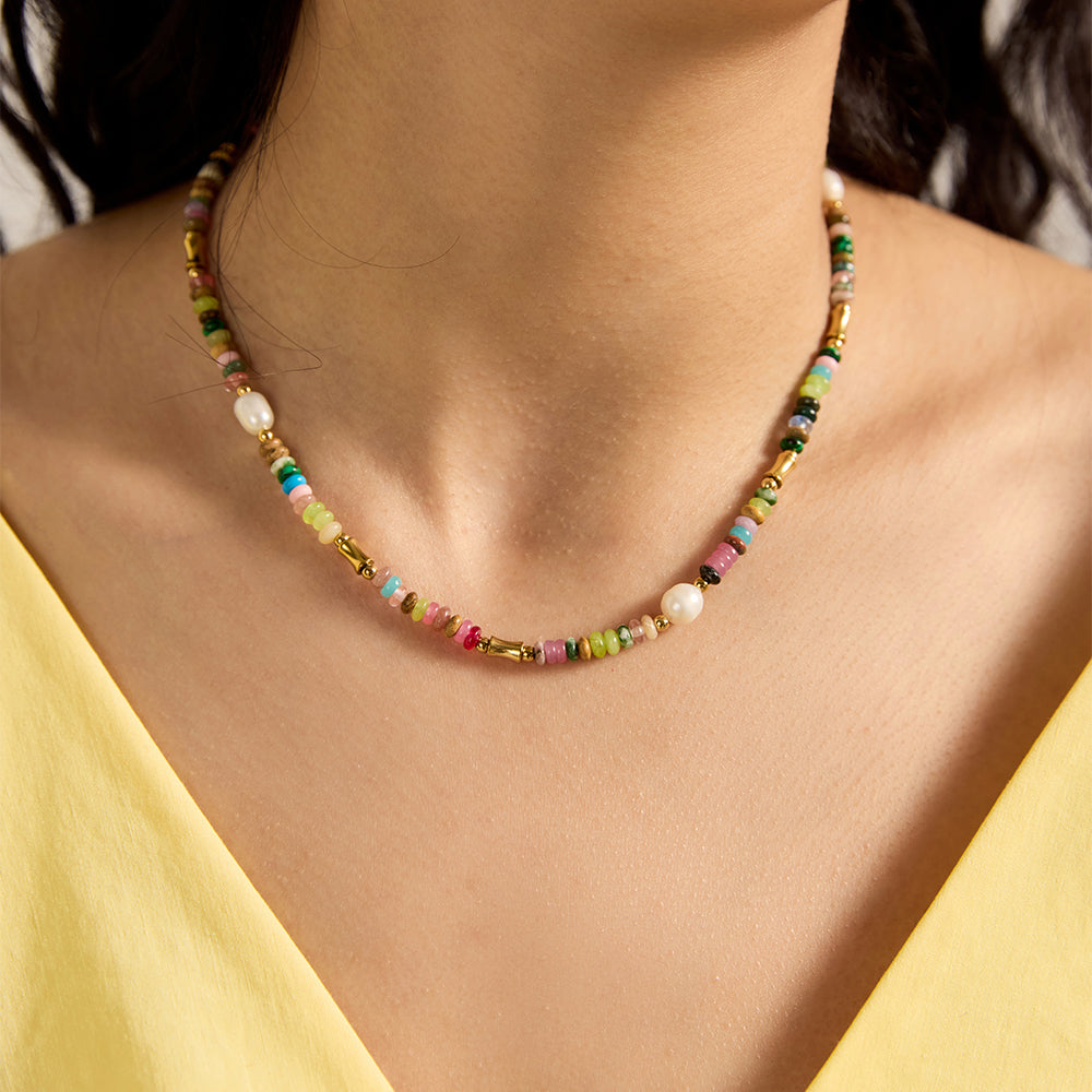 Woman wearing vibrant multi-color beaded necklace, showing pearl and bead details.