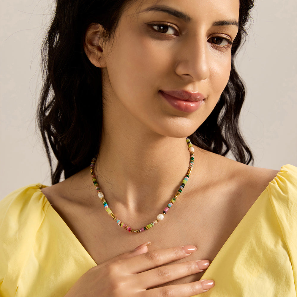 Woman wearing vibrant multi-color beaded necklace, showcasing its cheerful style.