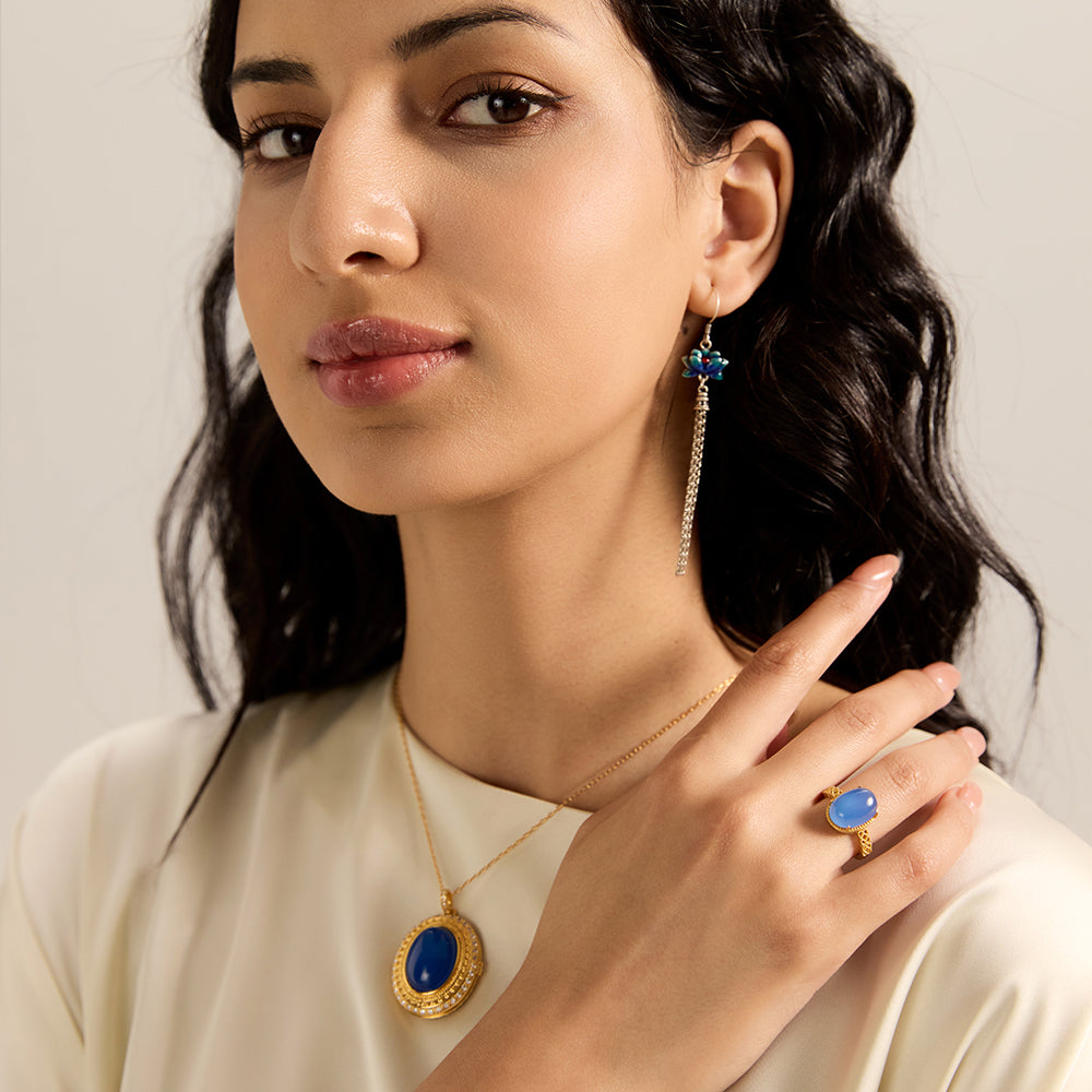 Model showcasing spiritual gold tone oval blue gemstone amulet necklace, complementing a spiritually aligned look.