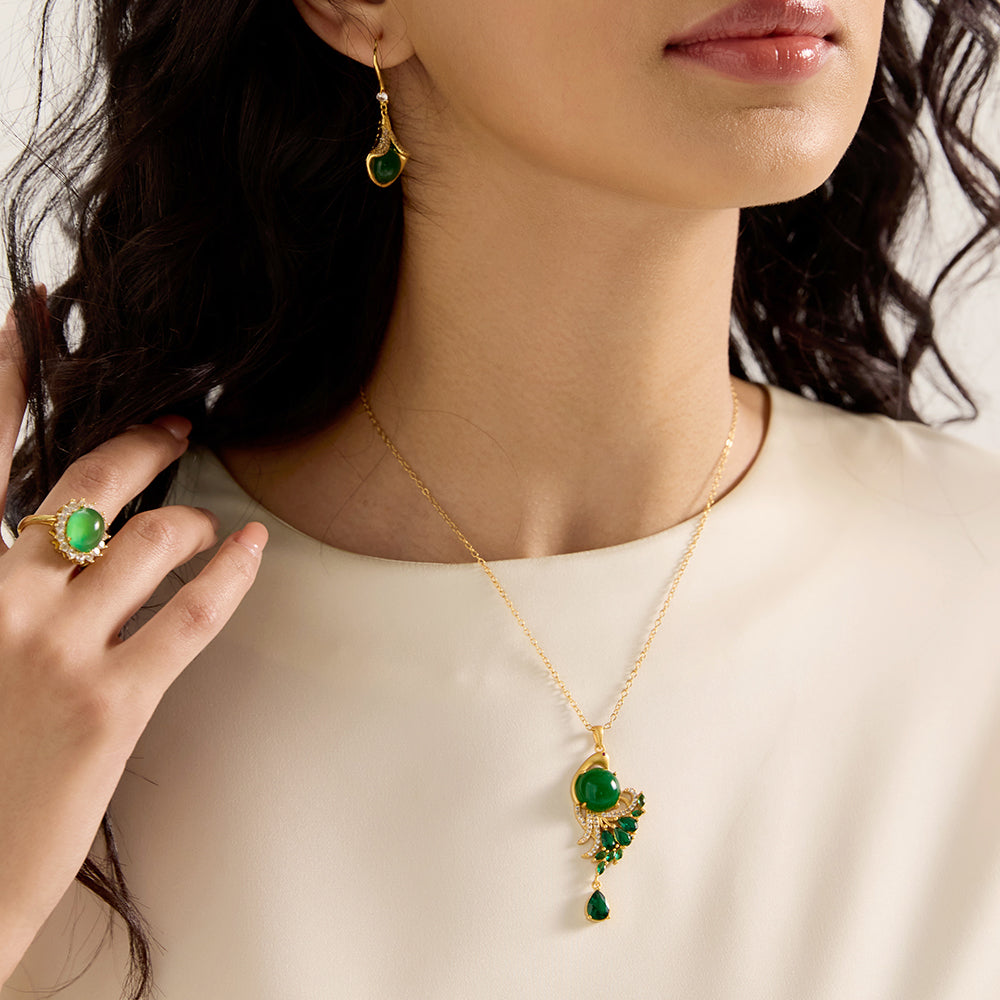 Detailed view of spiritual gold tone peacock green gemstone amulet necklace, showing marquise crystals and teardrop.