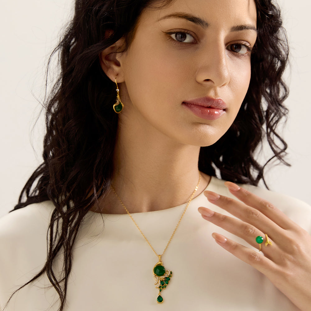 Model showcasing spiritual gold tone peacock green gemstone amulet necklace, complementing a sophisticated and energetically aligned look.