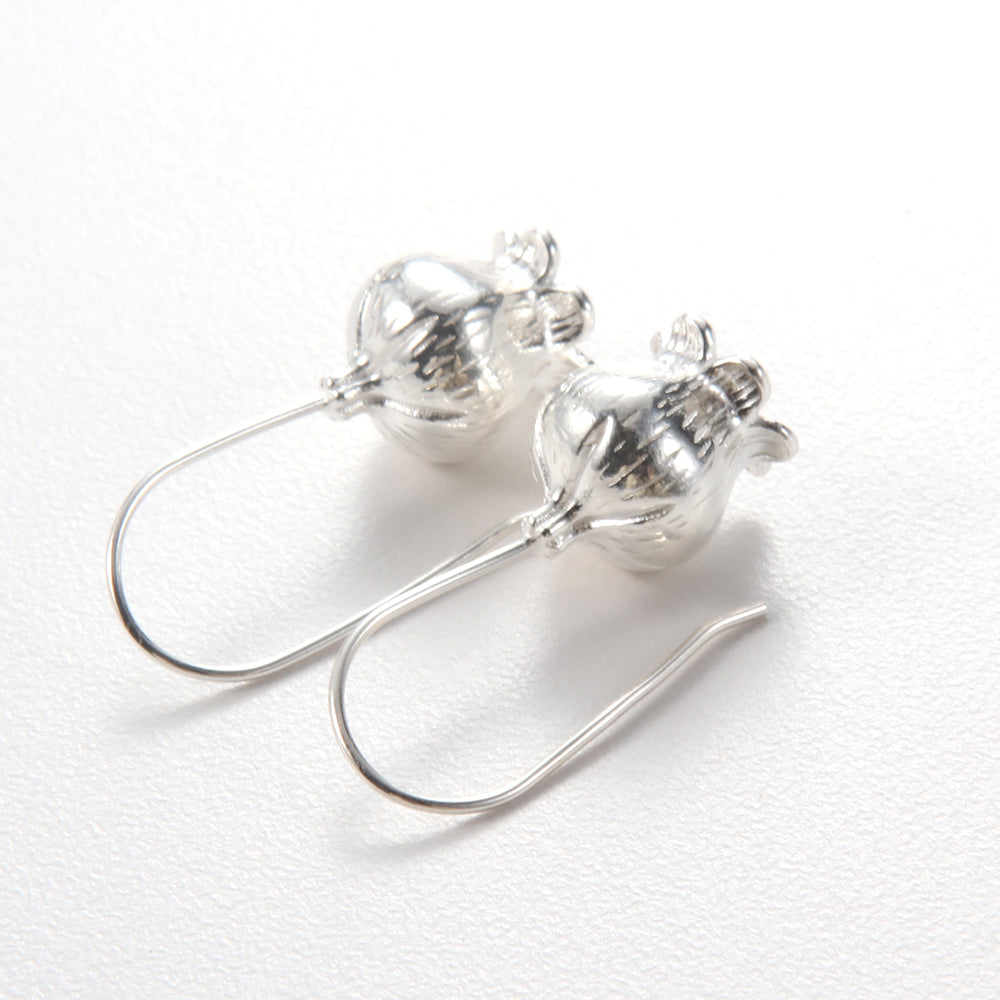 Profile view of woman wearing sterling silver round pearlized stud earrings.